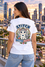 A woman wearing a white short-sleeve T-shirt with a large cartoon cat graphic and the words 'STITCH WITH LOVE' on the back, paired with light blue jeans, shown against a plain white background.